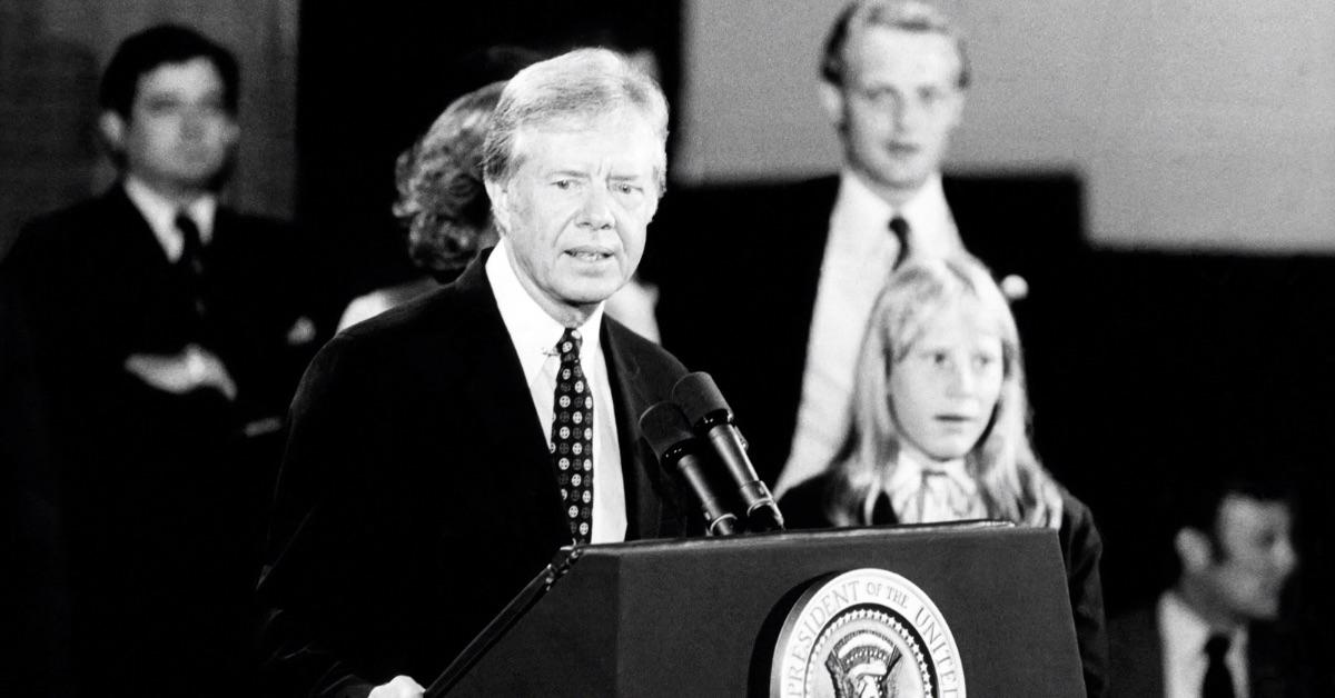 Jimmy Carter speaking at a podium with Amy by his side. 