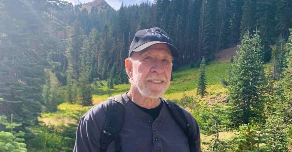 Chuck Norris on a hike with a backpack on.