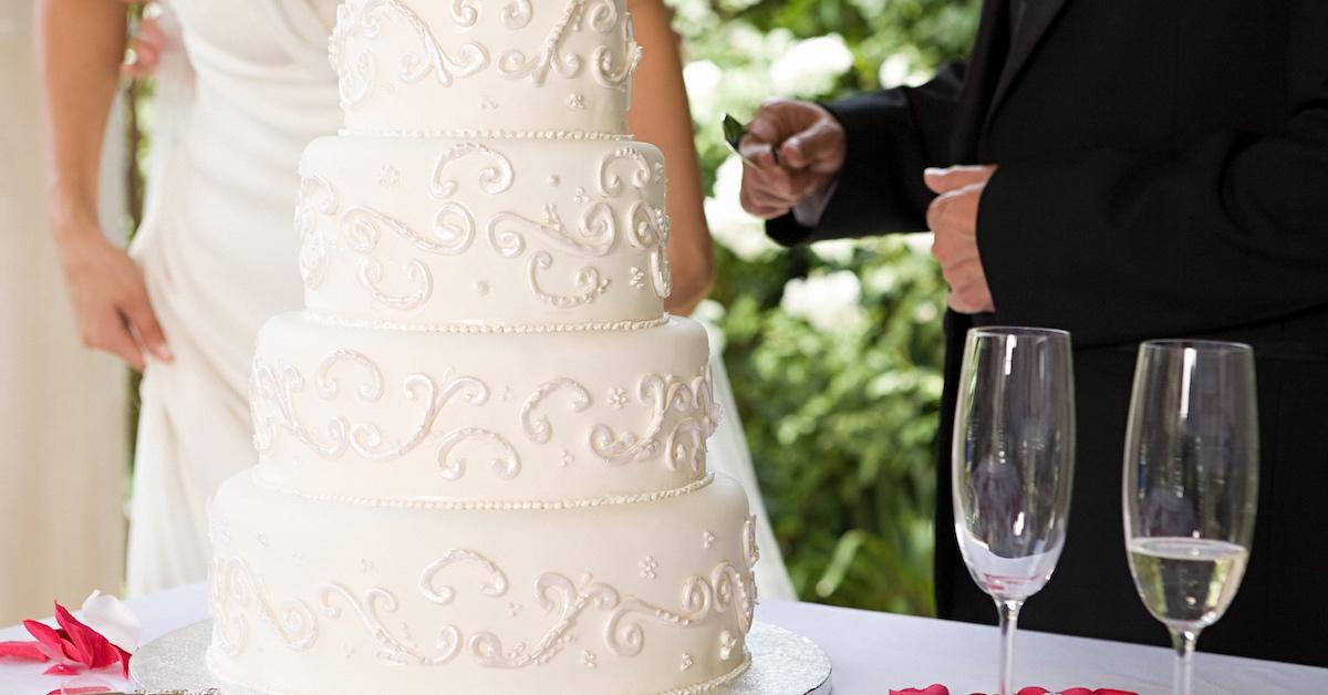 A wedding cake on a table with rose petals