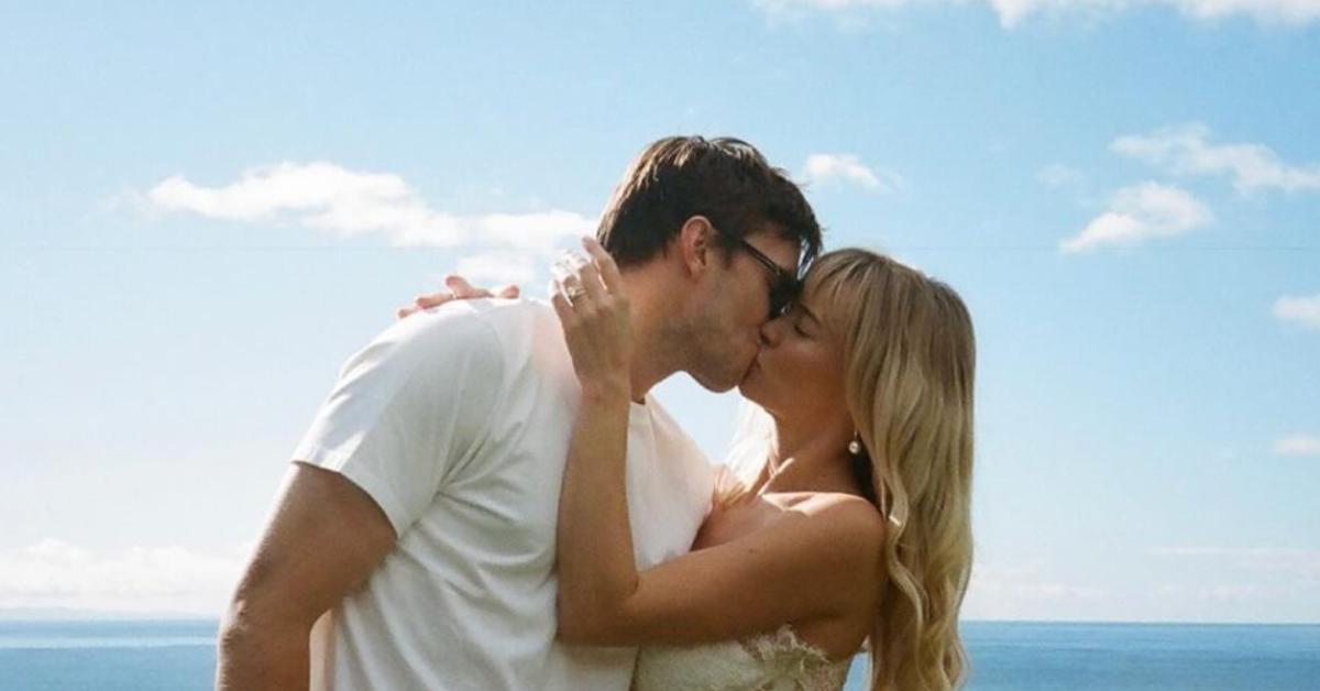 Nicholas Hoult and his wife, Bryana Holly, sharing a kiss by the water.