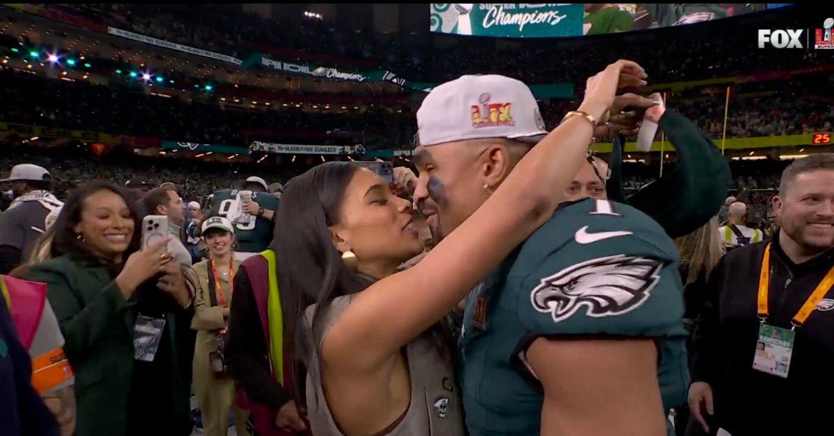 Jalen Hurts and Bry Burrows kissing on the field. 