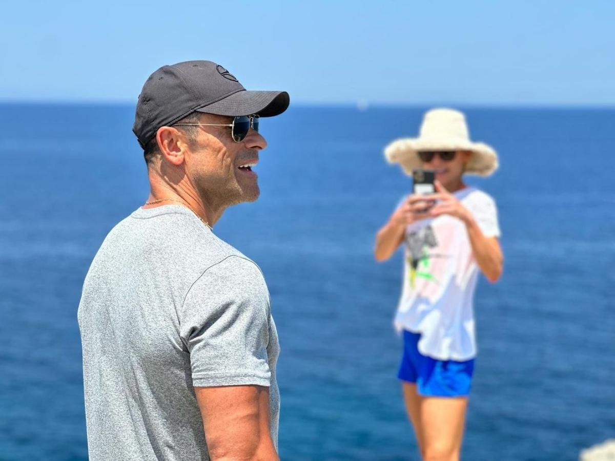 Mark Consuelos poses and smiles on the beach as Kelly Ripa Photographs him