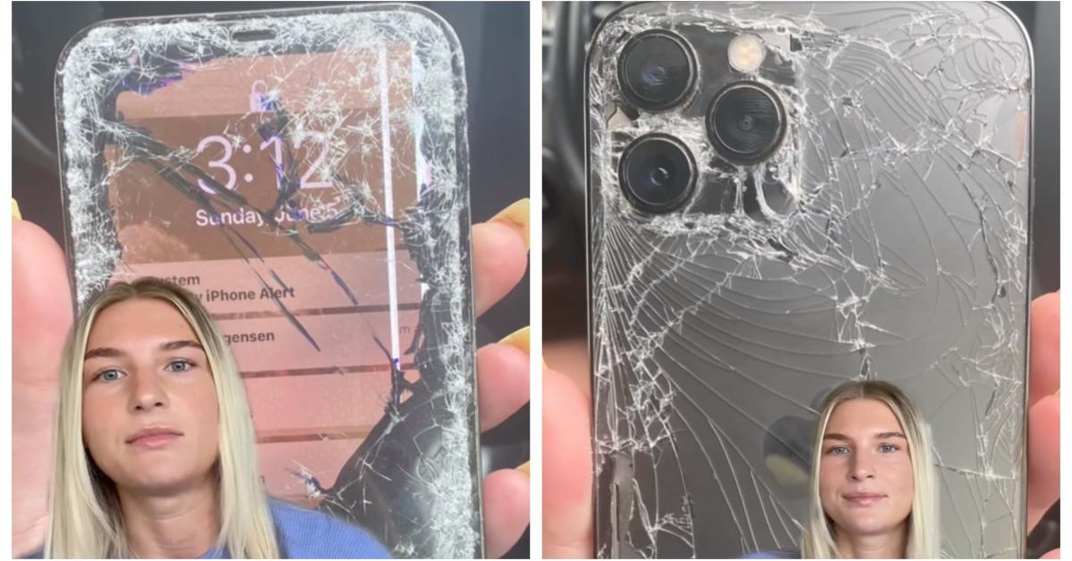 A woman shows her phone that was damaged by the customer.