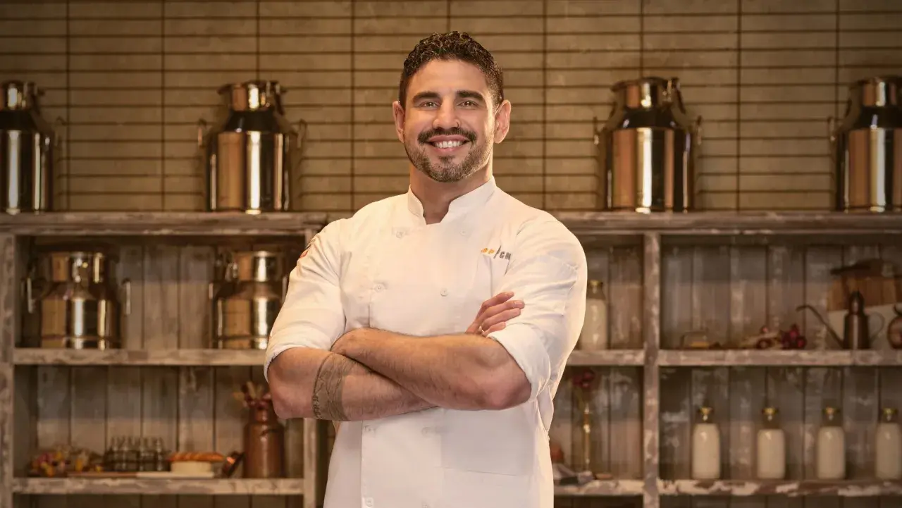 Manny wears a white chef's jacket for his official 'Top Chef: Wisconsin' portrait.