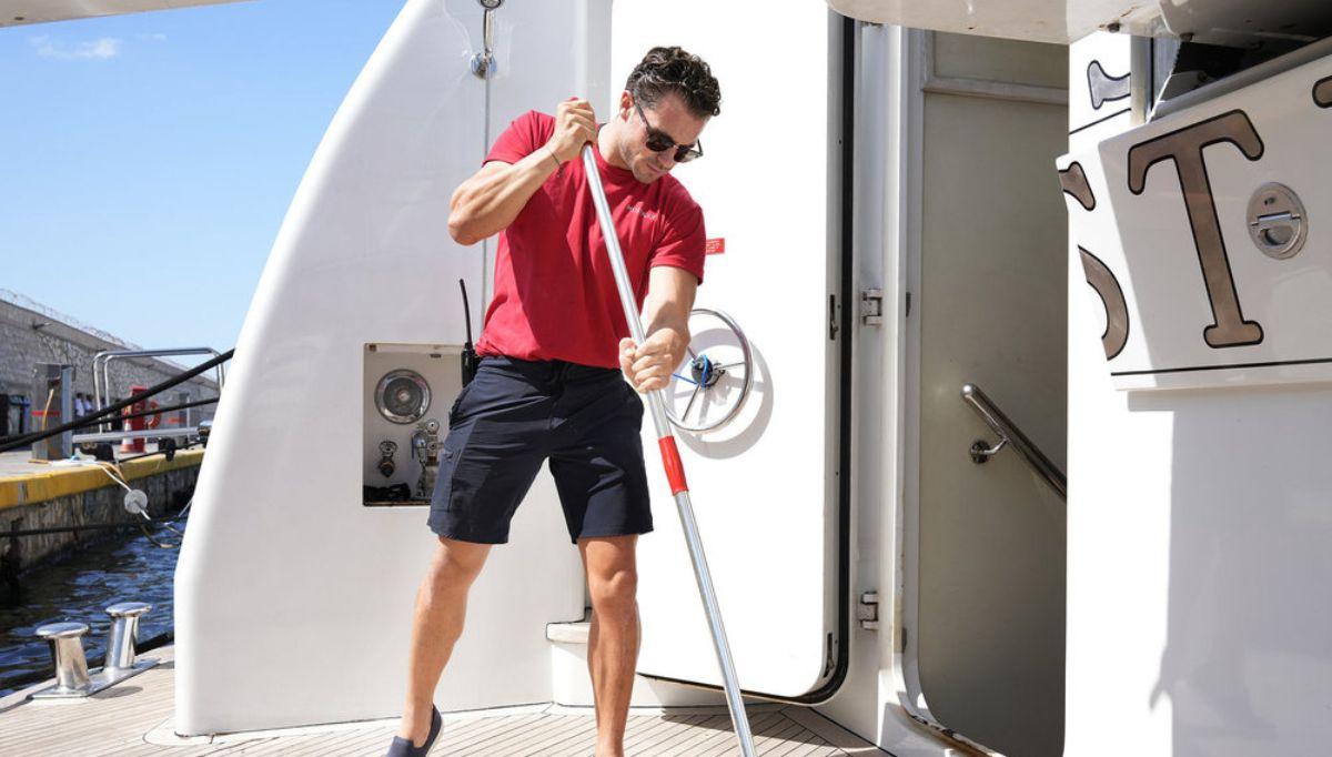 Deck hand Joe Bradley cleans the deck of the Mustique