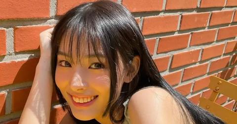 JINI smiling next to a brick wall