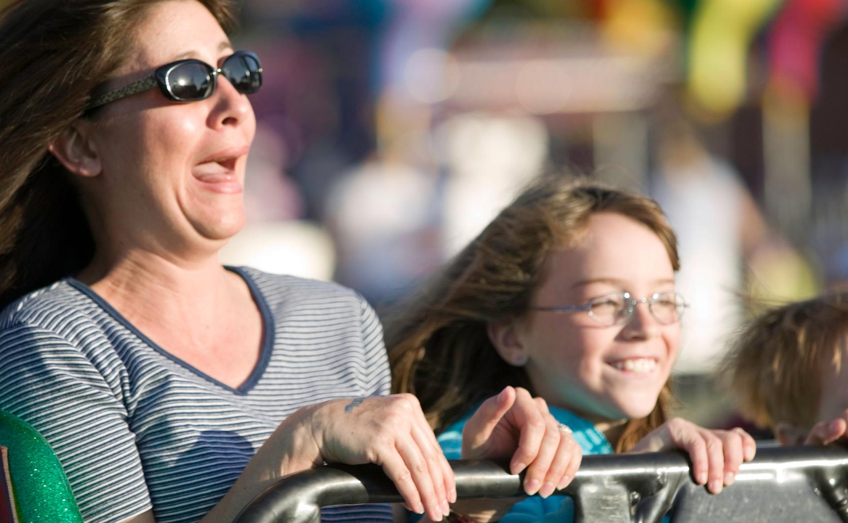 Still shot of woman and child on roller coaster.