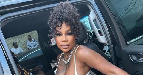 Sukihana sits in a car with the door open.