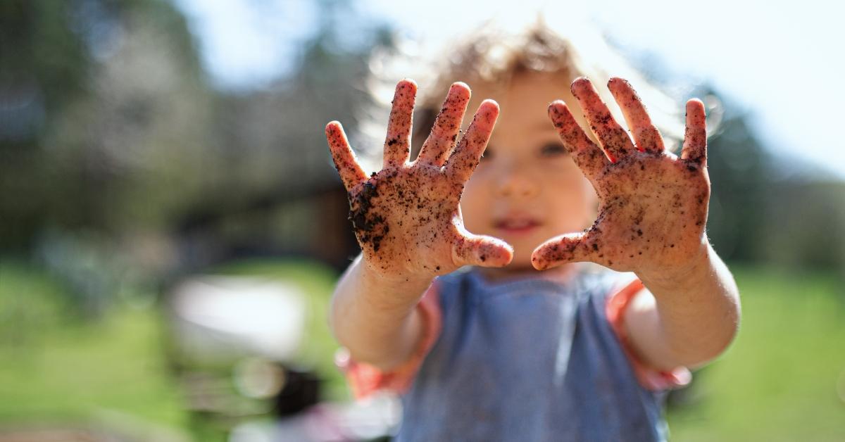 Child with hands covered in dirtt