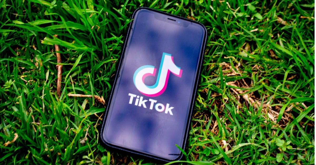 A phone loading TikTok sitting in the grass