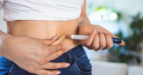 A person injecting their stomach