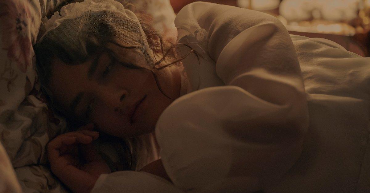 Becka laying in the bed after marrying Garth.