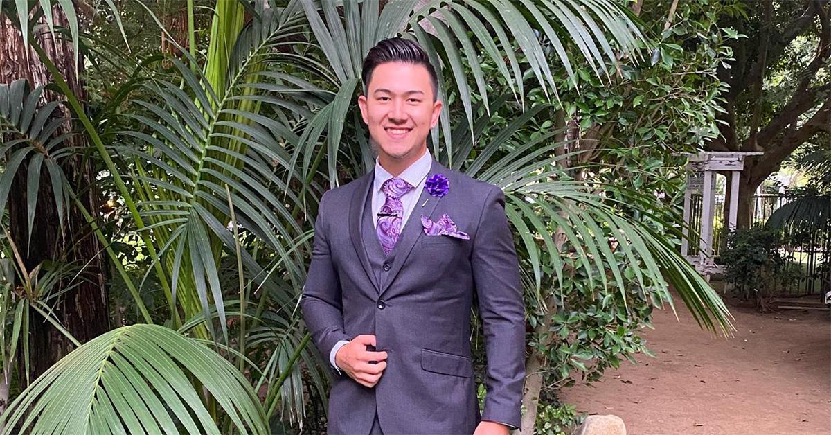 Bobby Fredrick in a three-piece suit with a purple tie and flower. 