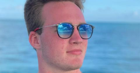 Zak Herbstreit wearing sunglasses near the ocean.