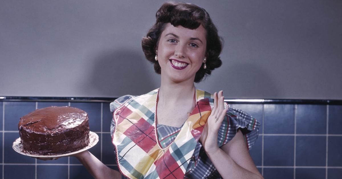 A housewife from the 1950s holding a cake