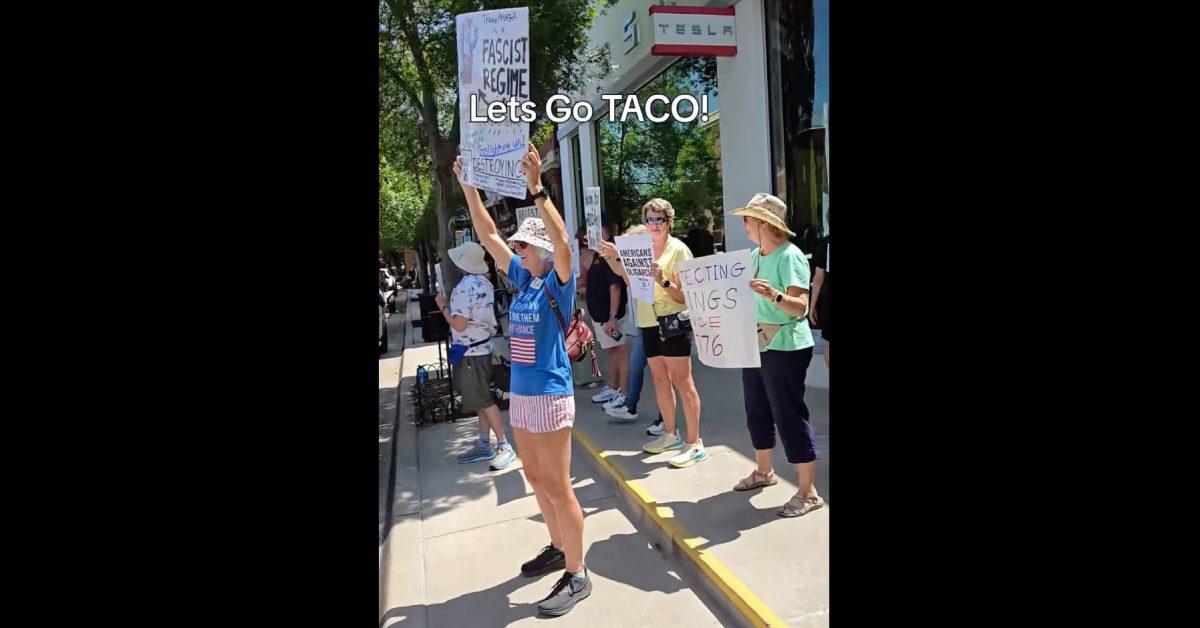 Protesters with signs chanting "Let's go taco."