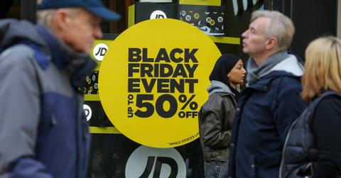 People walking by a Black Friday sale sign.