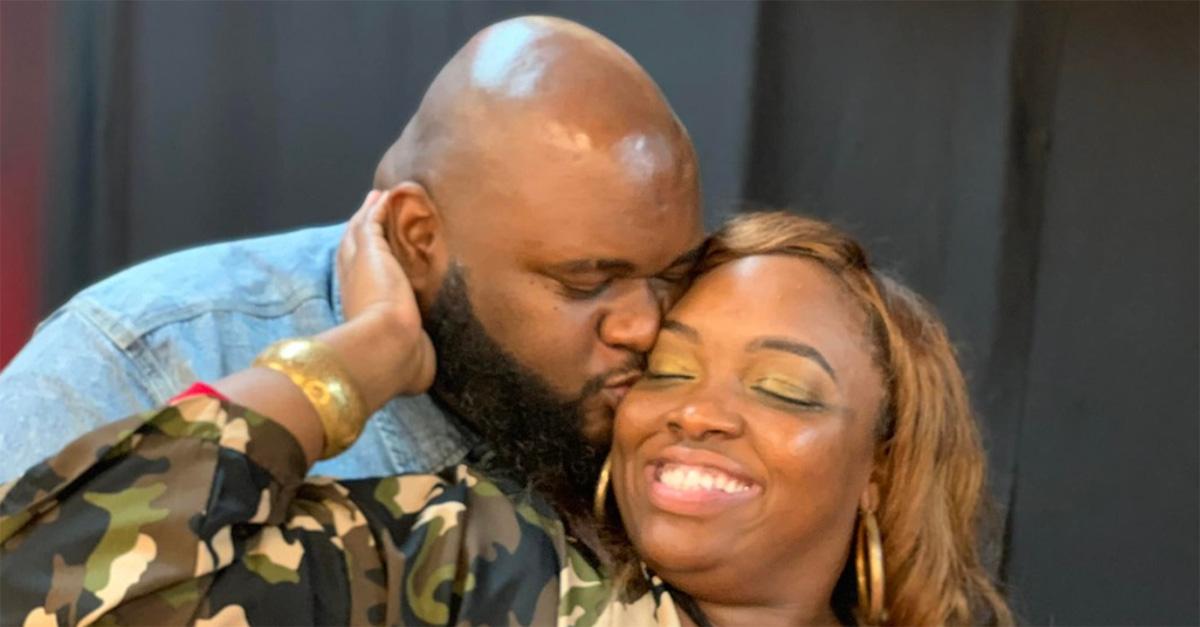 C. Ashley Brown-Lawrence with her husband Regi kissing her on the cheek. 