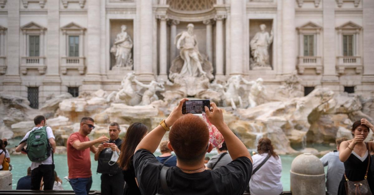  A tourist takes a picture at the Fontana di Trevi (Trevi Fountain)