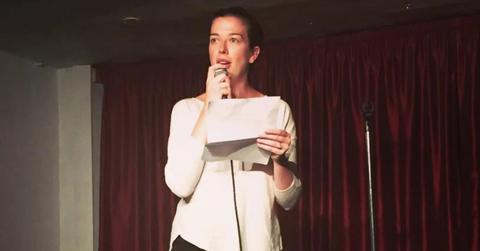 Claire Mulaney in a white shirt performing on stage