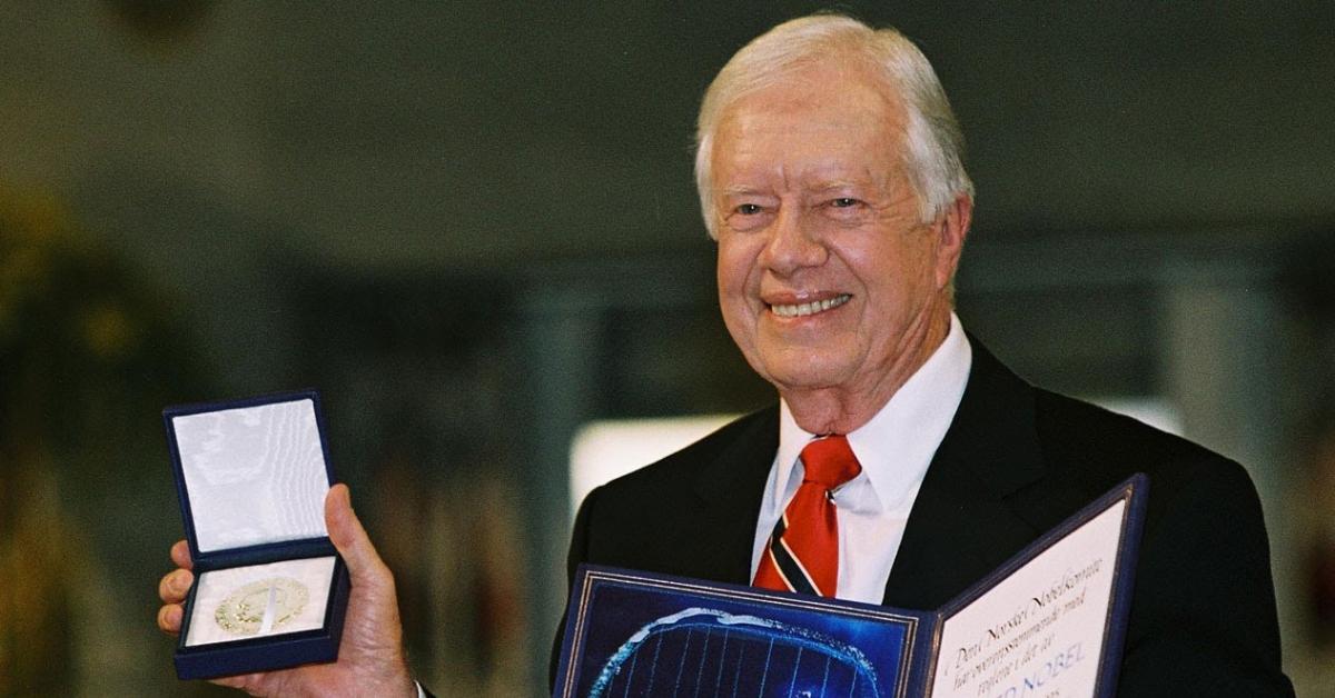 The 39th President of the United States, Jimmy Carter, posing with his Nobel Peace Prize in 2002.