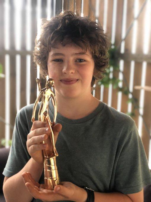 Finn Little holding an award for 'Storm Boy'