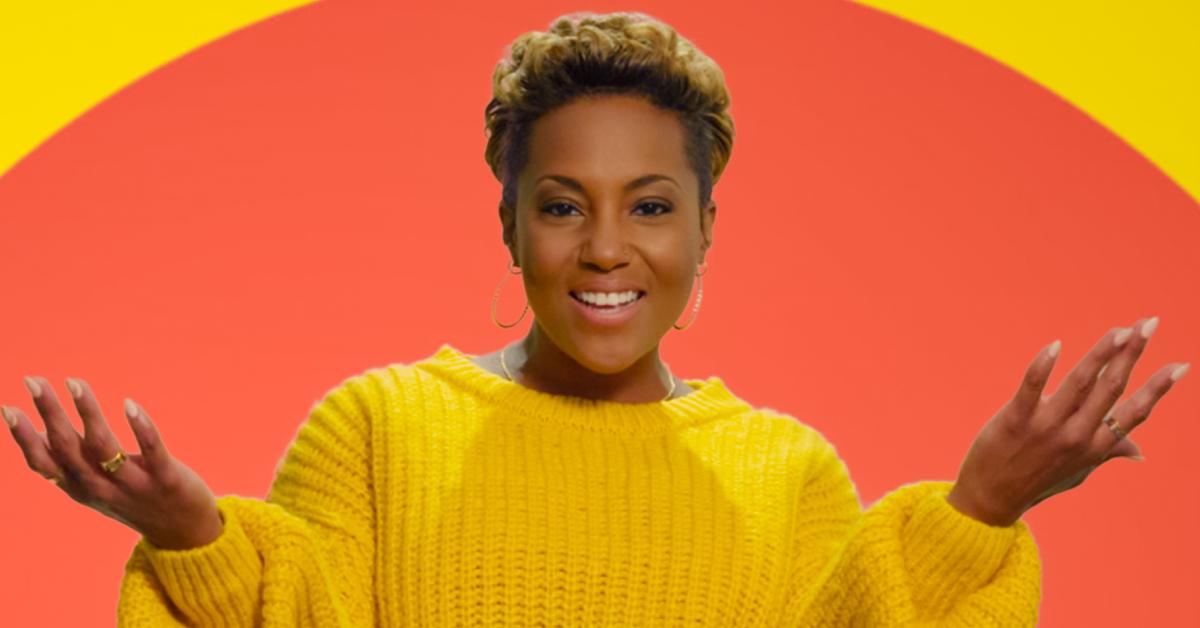 Caress Russell poses in front of an orange and yellow background for Season 6 of 'The Circle.'