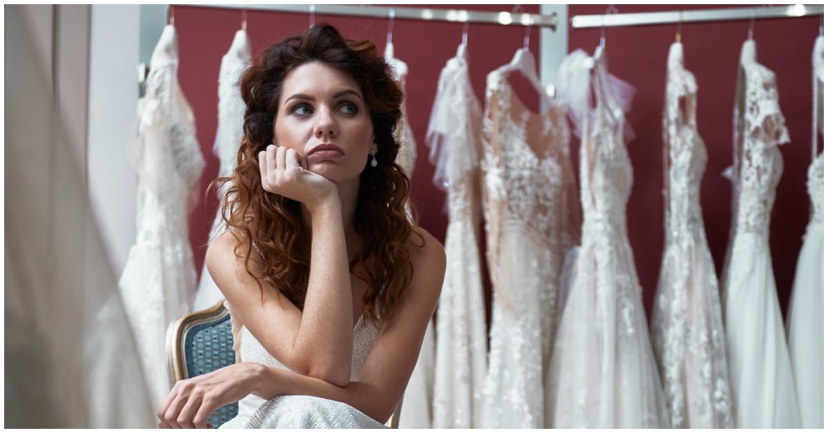 A future bride shrugging in a bridal shop.