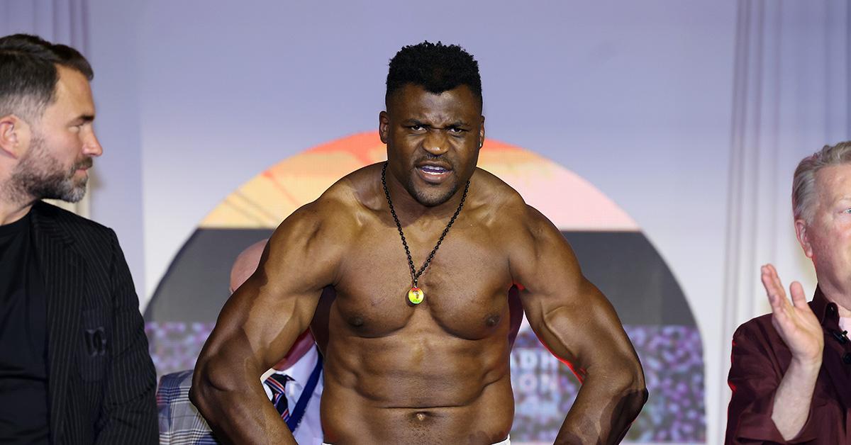 Francis Ngannou flexing his muscles during a weigh in. 