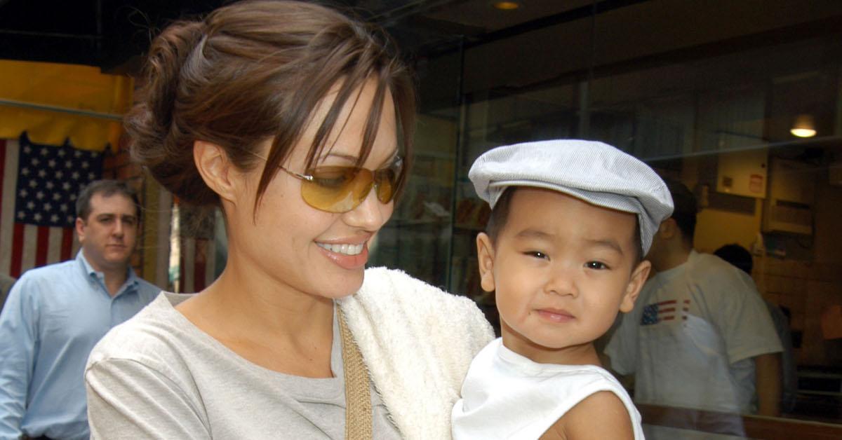 Angelina Jolie wearing shades and holding baby Maddox, approx. 2002