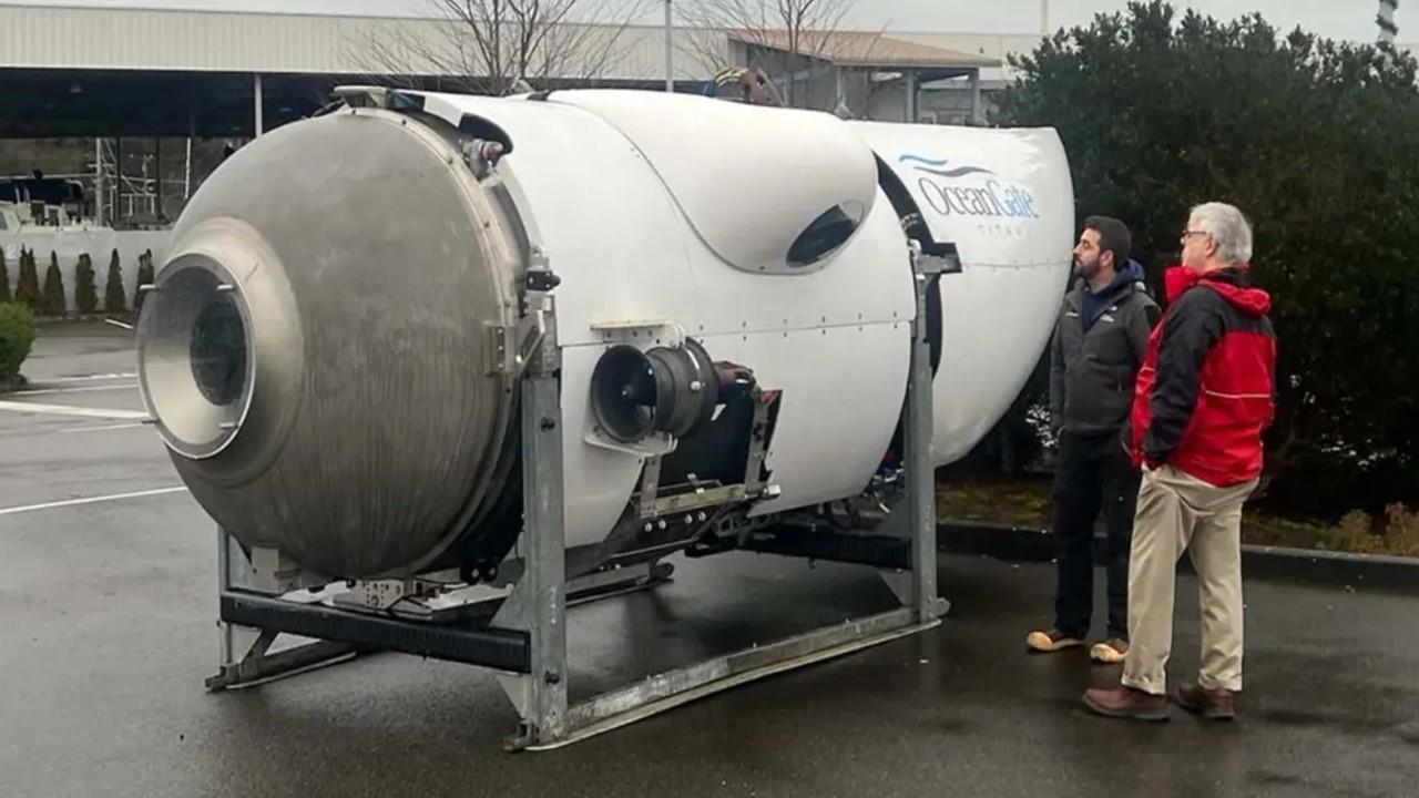 Two men looking at OceanGate's Titan submersible on land