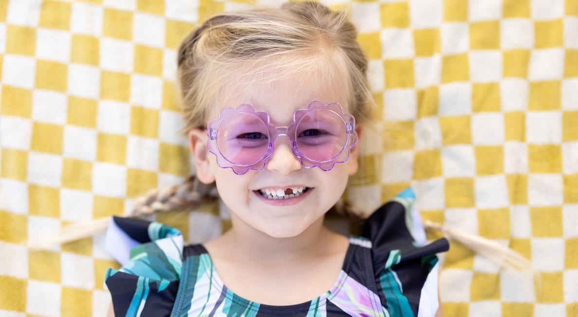 girl smiling with purple sunglasses