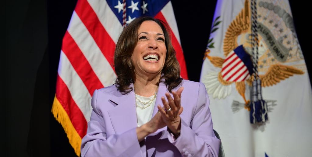 Kamala Harris wearing a purple suit and smiling