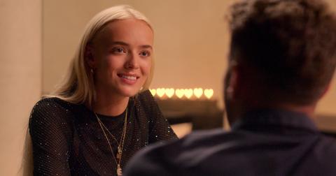 Elys Hutchinson, in a black sheer sparkly dress and gold jewelry, smiles at Harry Jowsey in Season 2 of 'Perfect Match.'