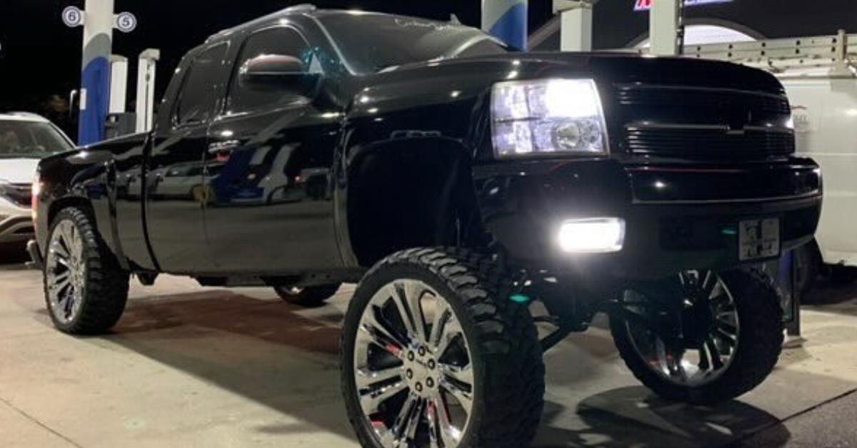 A black squatted truck at a gas station