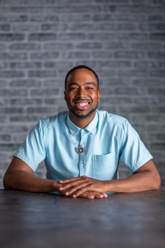 Quayly wears a short-sleeve blue button-up, smiling for his official portrait for Season 2 of 'The Mole.'