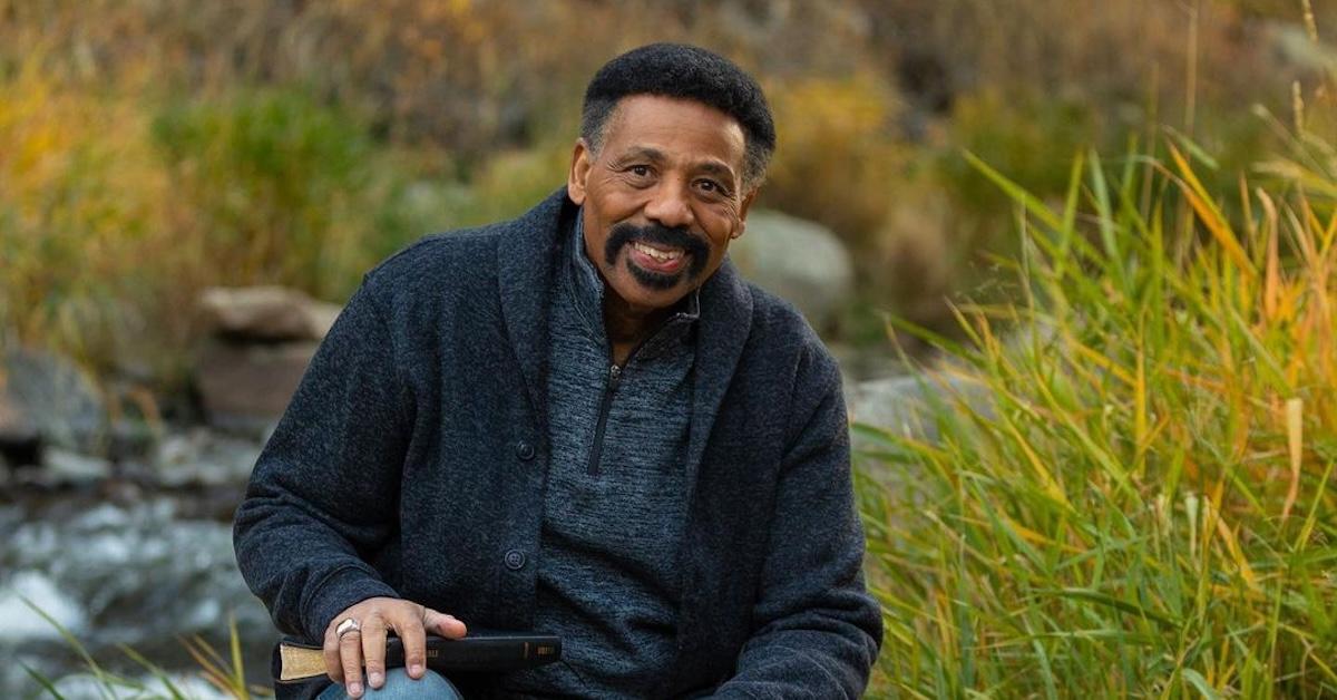 Dr. Tony Evans poses on a rock in front of a creek