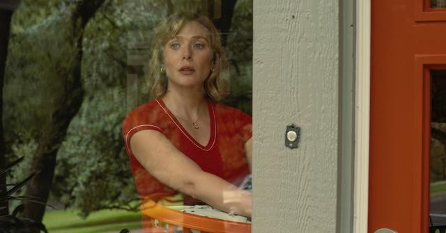 Elizabeth Olsen looks through window in 'Love & Death' holding laundry basket