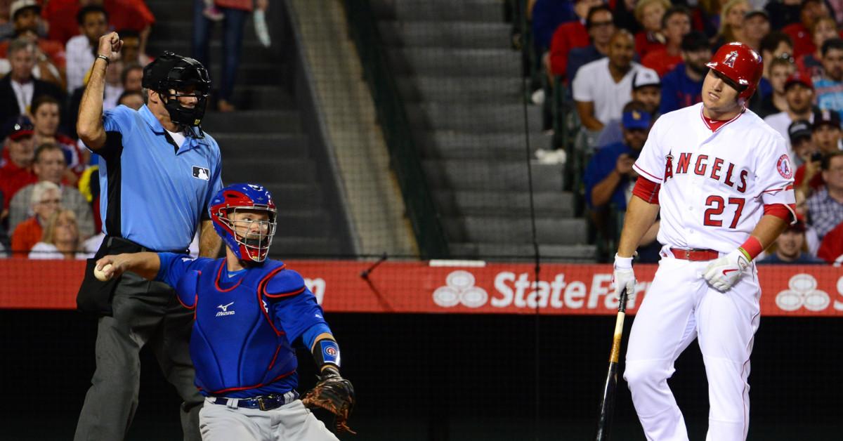 Los Angeles Angels' Mike Trout reacts after taking a strike from home plate umpire Ángel Hernández as Chicago Cubs catcher David Ross looks on during an MLB game at Angel Stadium of Anaheim in Anaheim, Calif., on April 5, 2016