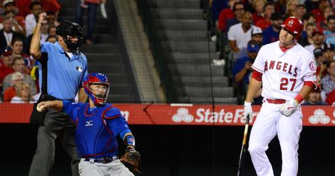 Los Angeles Angels' Mike Trout reacts after taking a strike from home plate umpire Ángel Hernández as Chicago Cubs catcher David Ross looks on during an MLB game at Angel Stadium of Anaheim in Anaheim, Calif., on April 5, 2016