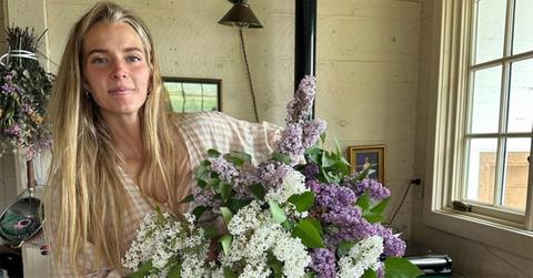 Hannah Neeleman standing with lilacs in her arms. https://www.instagram.com/p/CtehZlsOnvw/?hl=en