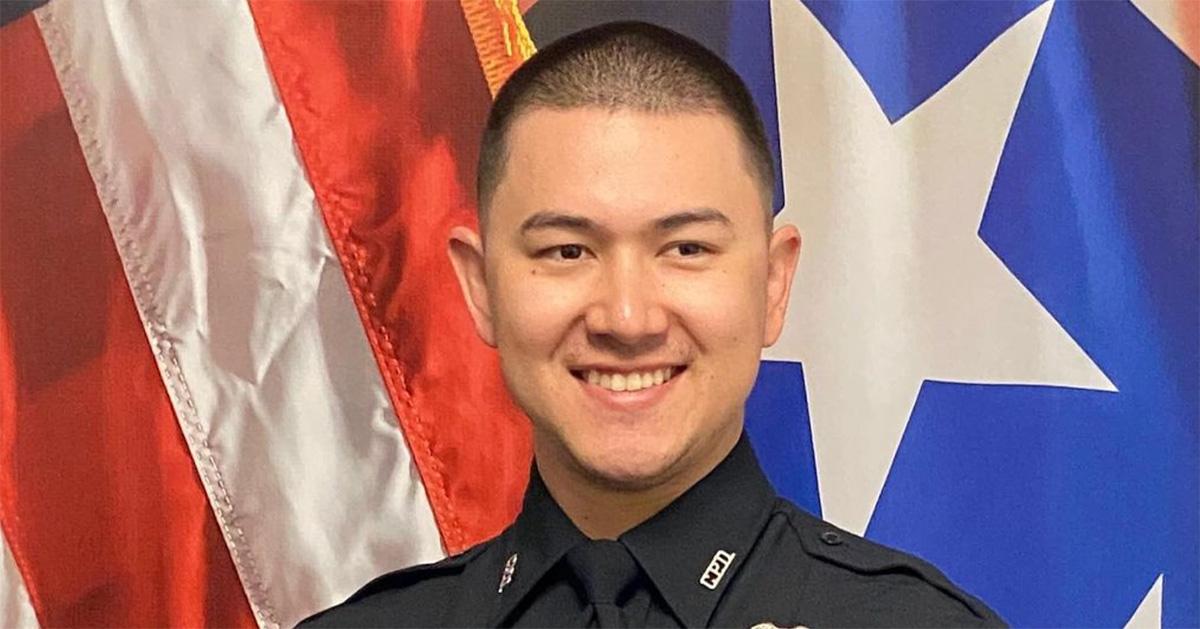 Bobby Fredrick in his police uniform with a flag behind him. 