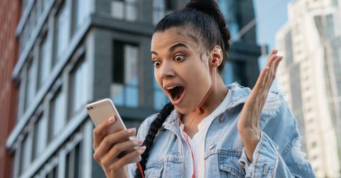 Woman Surprised Looking at Cell Phone Getty