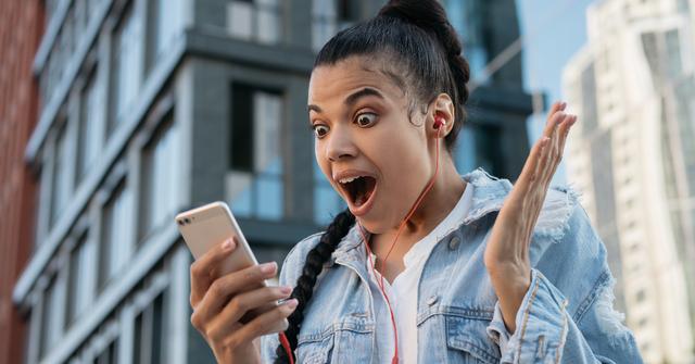 Woman Surprised Looking at Cell Phone Getty
