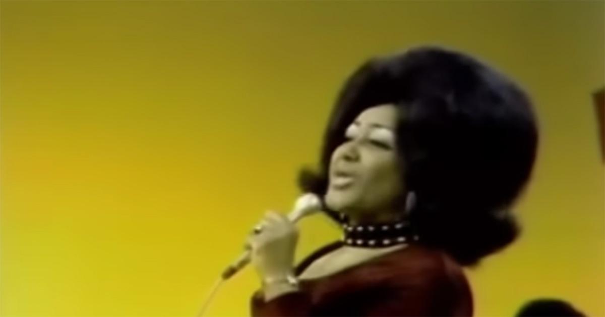 Jean Knight singing on 'Soul Train' with a yellow wall behind her. 