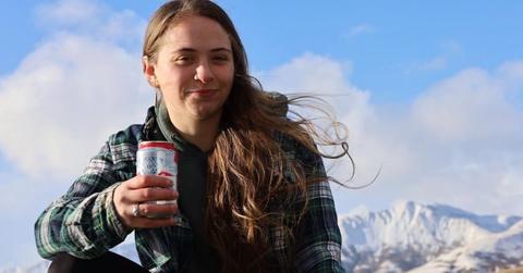 Sophia 'Bob' Nielsen holds a beer in front of mountains