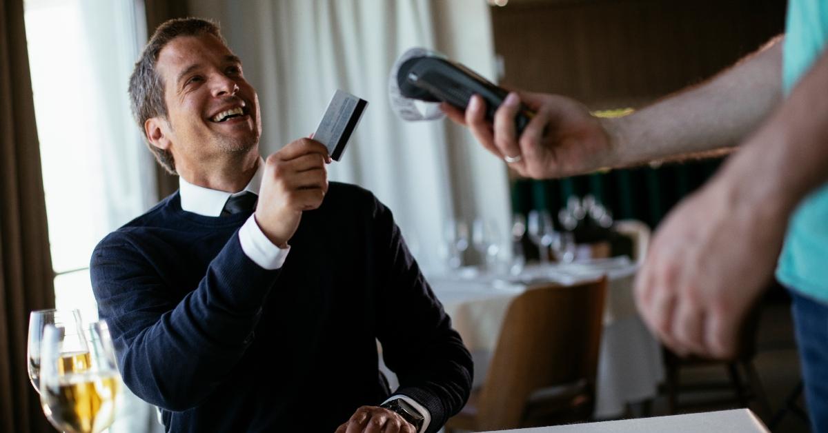 man giving waiter his card