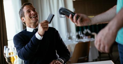 man giving waiter his card