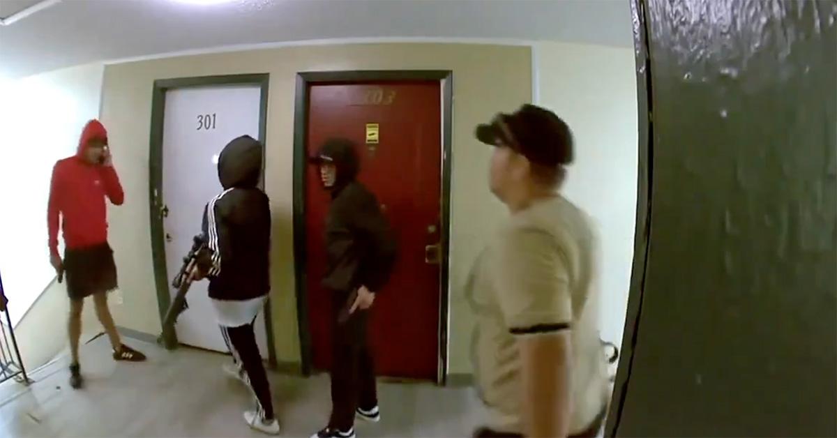 Several men with guns standing outside of an apartment door in Colorado. 