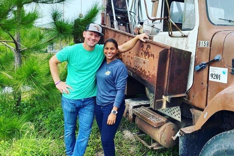 Brian and Mika outside, leaning against a truck